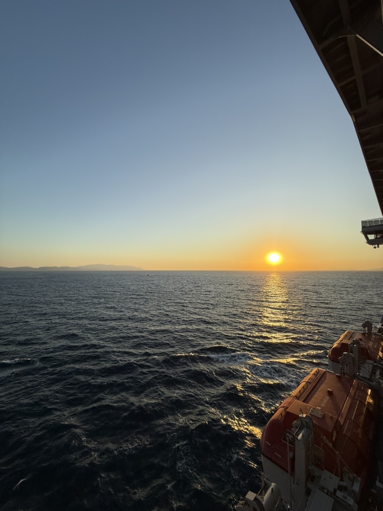 A golden sunset over the ocean viewed from a cruise ship